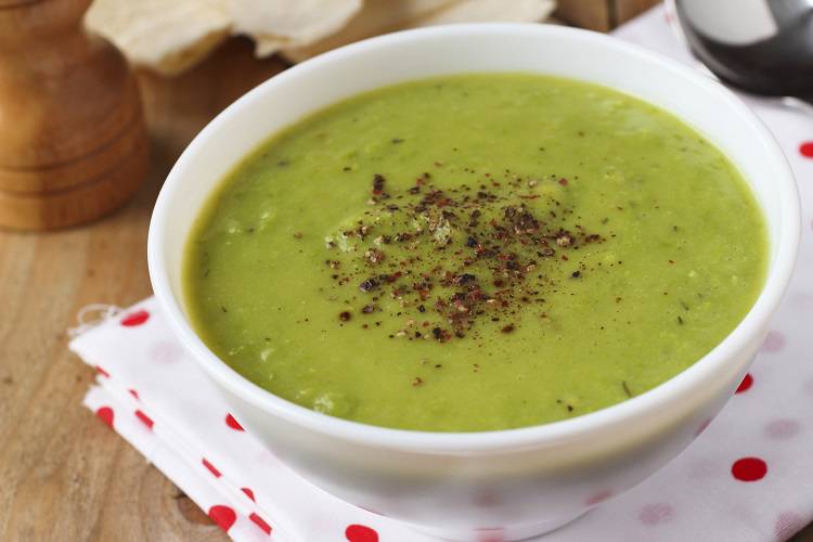 Vegan green pea soup with coconut milk and spices close-up